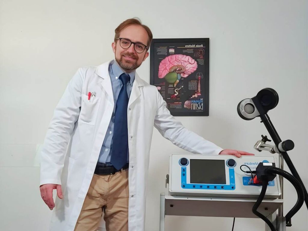Dr. Simone Di Pietro psichiatra specialista in dipendenze a Roma accanto al macchinario TMS